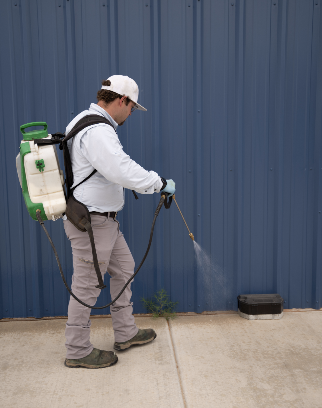 SWAT technician treating the exterior of a Lubbock commercial facility for pest control